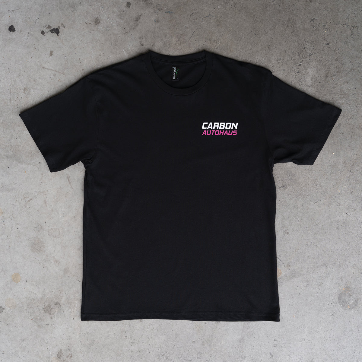 Black t-shirt with 'Carbon Autohaus' logo on a concrete floor