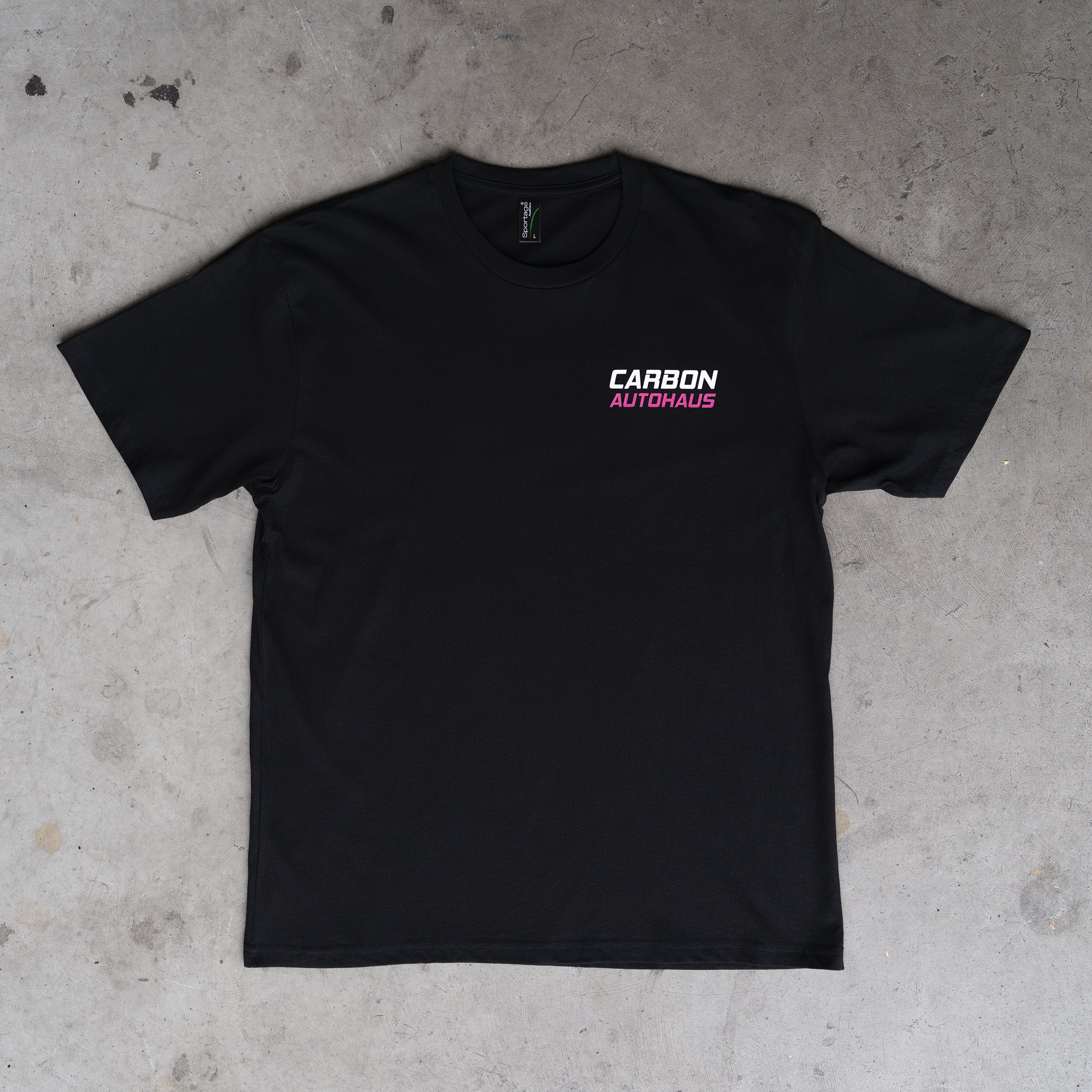 Black t-shirt with 'Carbon Autohaus' logo on a concrete floor