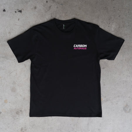 Black t-shirt with 'Carbon Autohaus' logo on a concrete floor